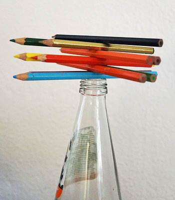 Die Teilnehmer müssen Bleistifte auf einem Flaschenhals stapeln.