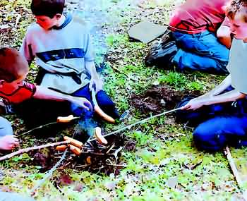 Jedes Team hebt mit dem Spaten eine Feuerstelle aus, grillt Würste und verschließt die Feuerstelle wieder sorgfältig.